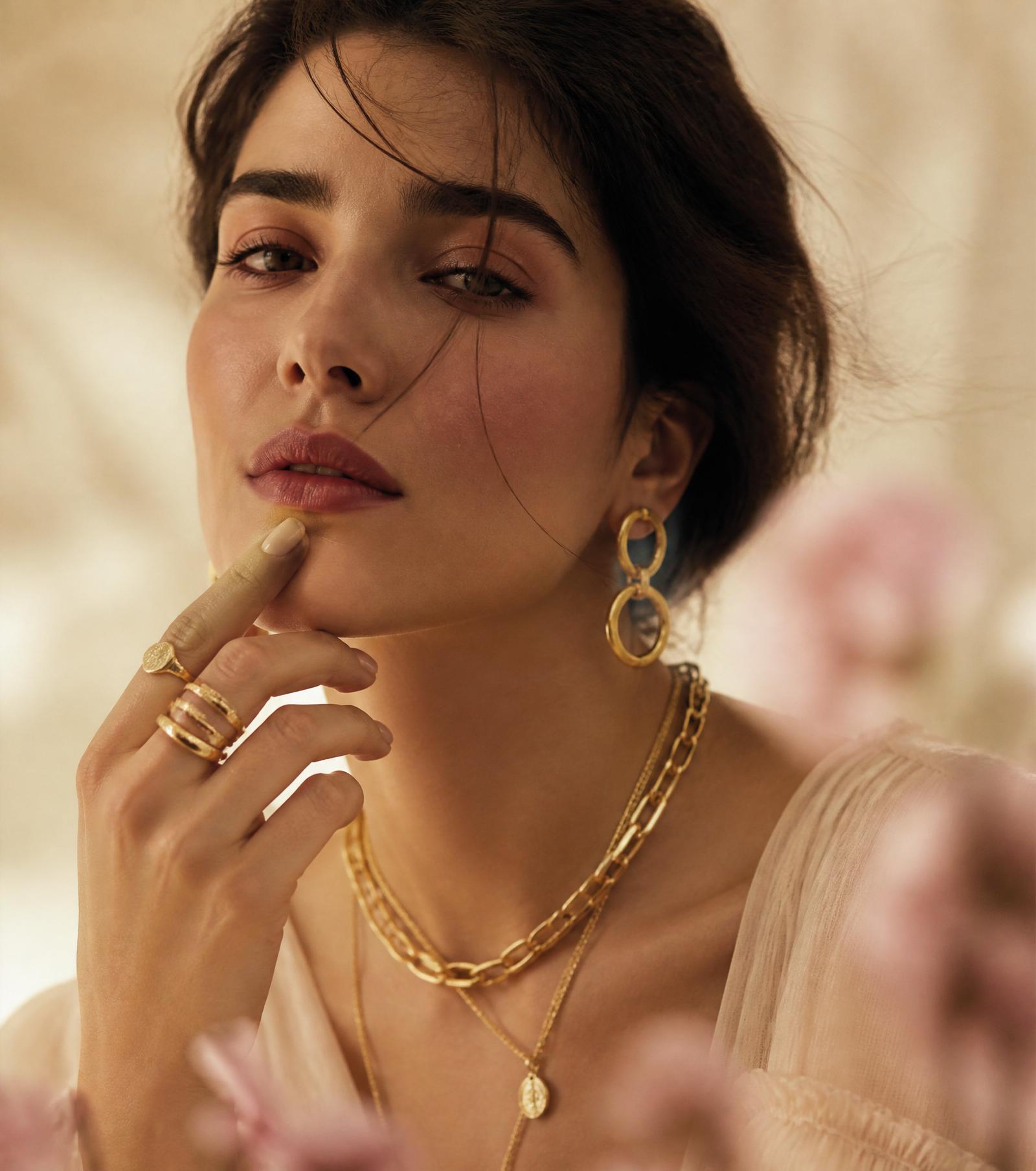 Model wearing layered gold jewellery
